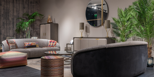 Modern living room with gray sofa, ottoman, and decorative elements.