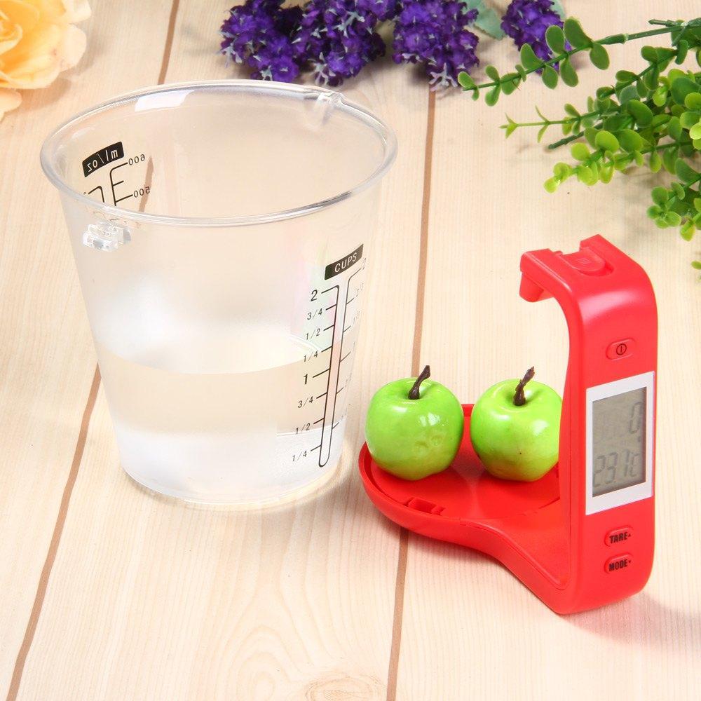 Digital LCD measuring cup scale in use weighing ingredients for cooking or baking