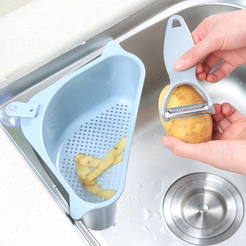 Kitchen sink drain basket organizer in use while peeling a potato
